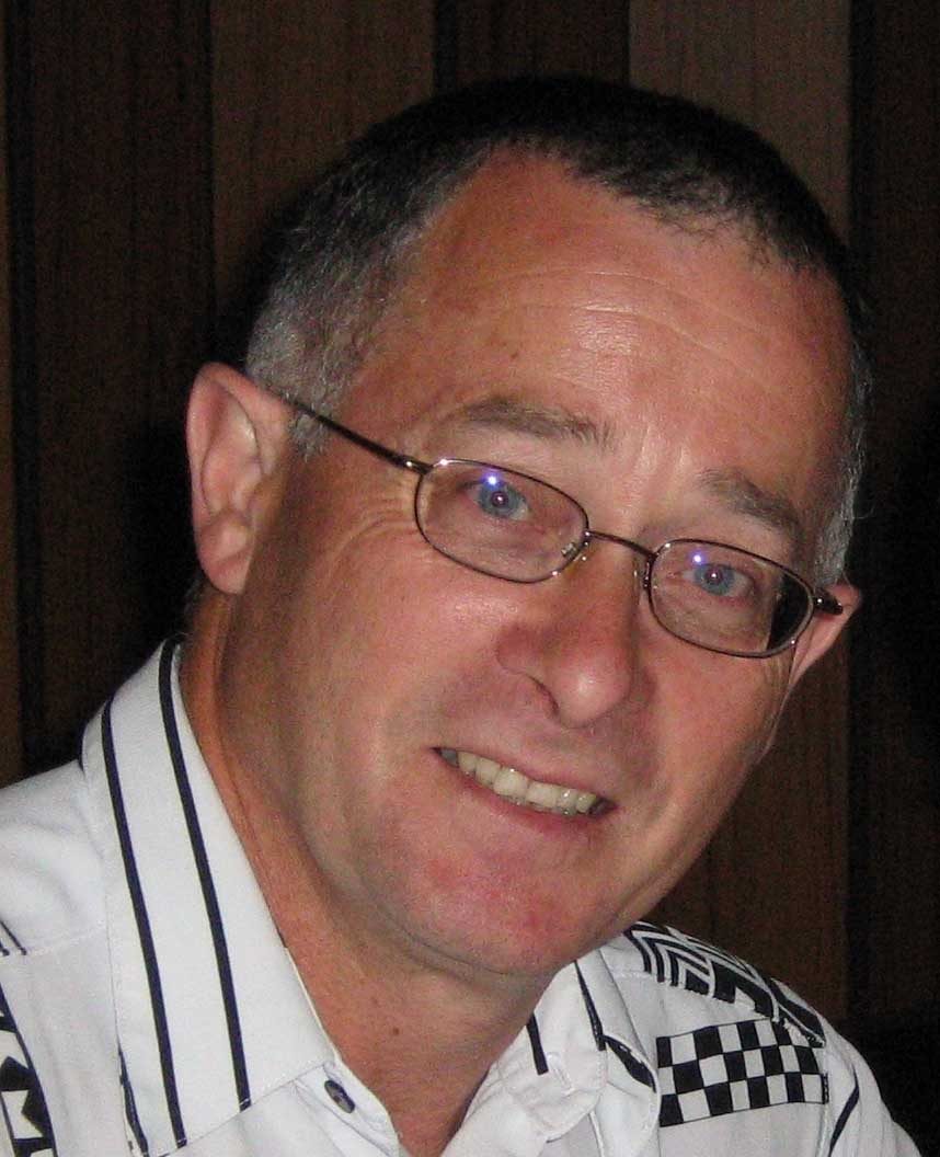 Roy Courtney, smiling, in glasses and a checked shirt